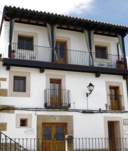a white building with windows and balconies at Apartamentos Rurales Entre Fuentes in Cuacos de Yuste