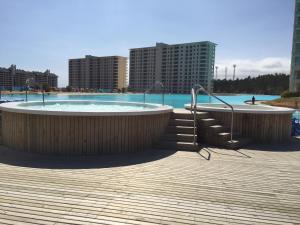 una piscina con bañera de hidromasaje y escaleras en Laguna Bahía Apt. 602, en Algarrobo