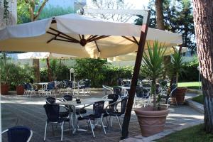 巴里的住宿－維多利亞公園酒店，一个带桌椅和遮阳伞的庭院