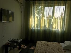 1 dormitorio con 1 cama y una ventana con cortinas en Guest House Salcia, en Maliuc