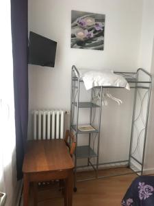 a room with a table and a chair and a shelf at Hotel Restaurant l'Avenir in Saint-Pierre-des-Corps