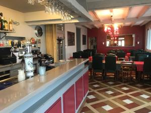 un restaurant avec un bar et une salle à manger avec des chaises dans l'établissement Hotel Restaurant l'Avenir, à Saint-Pierre-des-Corps