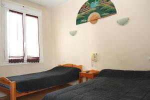 - une chambre avec 2 lits et 2 fenêtres dans l'établissement Hotel Restaurant l'Avenir, à Saint-Pierre-des-Corps