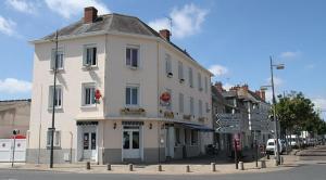 ein großes weißes Gebäude an der Ecke einer Straße in der Unterkunft Hotel Restaurant l'Avenir in Saint-Pierre-des-Corps