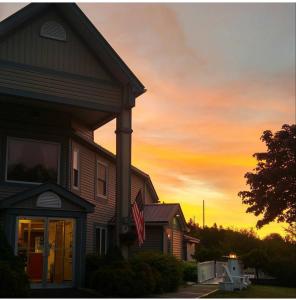 a house with a flag in front of a sunset at Granite Town Hotel in Saint George