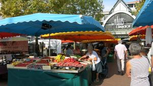 eine Gruppe von Menschen, die auf einem Markt mit einem Obststand spazieren in der Unterkunft La Jetée des Marins - Studio 103 in Arcachon