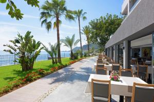 a restaurant with tables and chairs and the ocean at Floria Beach Hotel in Alanya