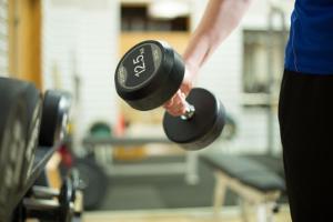 eine Person mit zwei Hanteln in einem Fitnessstudio in der Unterkunft Godby Vandrarhem in Godby