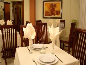 a table with white plates and napkins on it at Hotel Torre Norte in Trujillo
