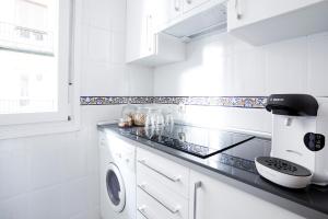 eine weiße Küche mit Waschmaschine und Trockner in der Unterkunft Royal Palace Boutique in Madrid