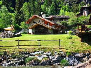 a house with a fence next to a river at B&B Lo Djoua de Toueno in Arvier