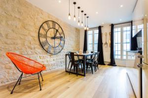 a dining room with a table and chairs and a clock at CMG Montorgueil X in Paris