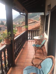 a balcony with chairs and a table with a view at Apartamentos Casa de la Abuela in Potes