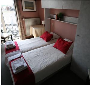 a bedroom with a large bed with red pillows at Hotel Anvers in De Panne