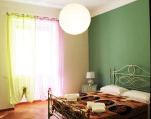 ローマにあるA Casa Di Magda (Al centro di Roma)の緑の壁のベッドルーム1室(大きな窓付)