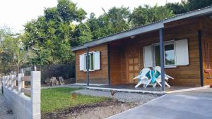a small cabin with a porch with a couple of chairs at R'Marine439 locations saisonnières in La Marine
