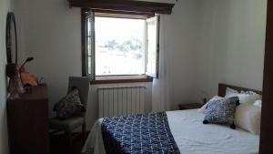 a bedroom with a bed with a window and a chair at Casa do Lavrador in Casal +15 photos