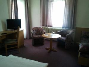 a hotel room with a table and chairs and a tv at Gästehaus Galant in Esslingen