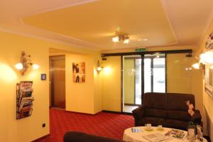 a living room with a chair and a table at Hotel Post in Scheidegg