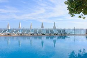 a row of chairs sitting next to a swimming pool at Floria Beach Hotel in Alanya