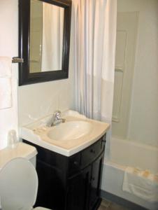 bagno con lavandino, servizi igienici e specchio di San Juan Motel ad Anacortes