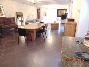 a living room with a wooden table and chairs at Gite Le Clos Constance in Charrais