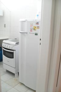einen weißen Kühlschrank in einer Küche neben einem Herd in der Unterkunft Apartamento Salvador in Salvador