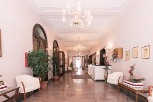 a hallway with a chandelier and white walls at Hotel Europa in Ferrara