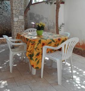トッレ・ラピッロにあるVilla Graziaの白い椅子と花のテーブルクロス