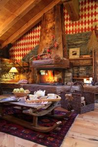 a living room with a table and a fireplace at B&B Lo Djoua de Toueno in Arvier