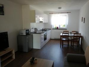 sala de estar con cocina y mesa con sillas en Apartmán Sadová 430, en Chodová Planá