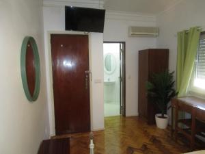 Habitación con puerta y altavoz en la pared en Pensão Residencial Luanda, en Tomar