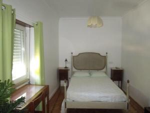托馬爾的住宿－盧安達旅館，一间卧室配有一张带白色床单的床和一扇窗户。