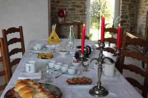 a table with a white table cloth with food and candles at Au p'tit Mont in Ardevon