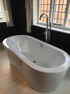 a white bath tub with a faucet in a bathroom at The Tailor's Flat in Rye