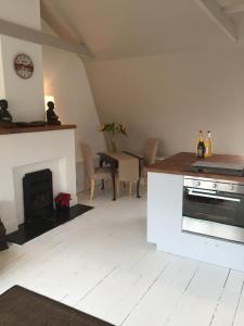 a living room with a stove and a fireplace at The Tailor's Flat in Rye