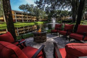 a patio with chairs and a fire pit in front of a pond at Westgate Leisure Resort in Orlando