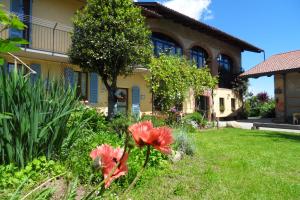 a house with a garden with flowers in the yard at B&B Cascina Marie in Bricherasio