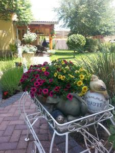 eine Gartenbank mit Blumen und einer Vogelstatue in der Unterkunft Ferienzimmer Familie Schmidt in Großdeuben