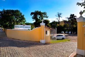una valla amarilla con un coche aparcado en un estacionamiento en Hotel Santa Amalia, en Vassouras