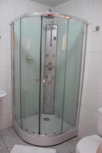 a glass shower in a bathroom with a toilet at Hostal Baquedano in Puerto Natales +37 photos