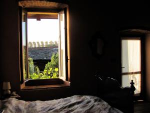 1 dormitorio con cama y ventana con vistas en B&B Cascina Marie, en Bricherasio