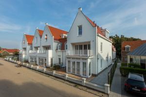 a row of white houses on a street at Duinhof Dishoek Luxe appartementen in Dishoek
