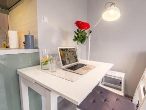 - un ordinateur portable installé sur un bureau blanc dans la cuisine dans l'établissement Lemonade Nowogrodzka, à Varsovie