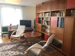sala de estar con mesa, sillas y estante para libros en Stylowy apartament Centrum Gdyni, en Gdynia