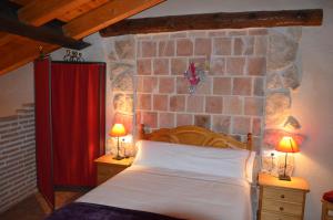 - une chambre avec un lit et un mur en briques dans l'établissement Casa LLovet, à Fuentespalda