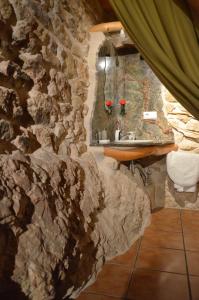 Baño de piedra con lavabo y pared de piedra en Casa LLovet, en Fuentespalda