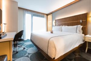 una camera d'albergo con un grande letto e una scrivania di Crowne Plaza HY36 Midtown Manhattan, an IHG Hotel a New York