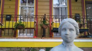a statue in front of a yellow building with windows at Creole Victorian for groups large and small in New Orleans
