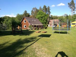 a large yard with a playground and a house at Likimo ratas in Paliepis